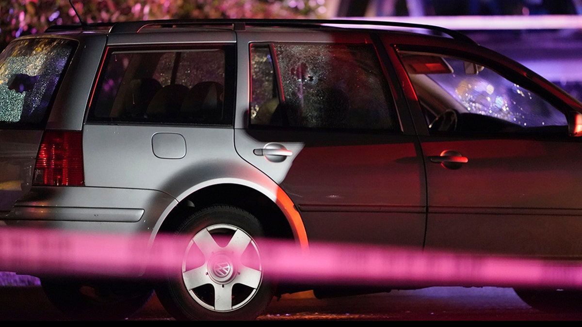 A car with shattered windows and likely bullet holes stands in the area where a man suspected of fatally shooting a supporter of a right-wing group in Portland, Ore., last week was killed as investigators moved in to arrest him in Lacey, Wash., Thursday, Sept. 3, 2020. (Associated Press)