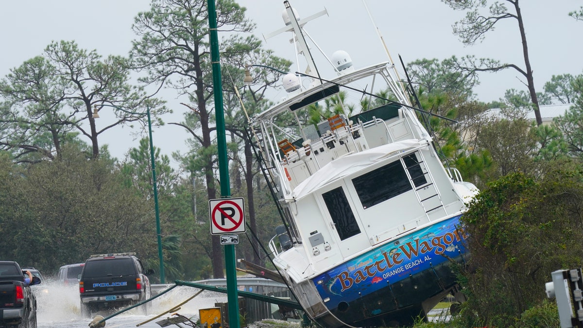 A boat is washed up near a road after Hurricane Sally moved through the area, Wednesday, Sept. 16, 2020, in Orange Beach, Ala. Hurricane Sally made landfall Wednesday near Gulf Shores, Alabama, as a Category 2 storm, pushing a surge of ocean water onto the coast and dumping torrential rain that forecasters said would cause dangerous flooding from the Florida Panhandle to Mississippi and well inland in the days ahead. (AP Photo/Gerald Herbert)