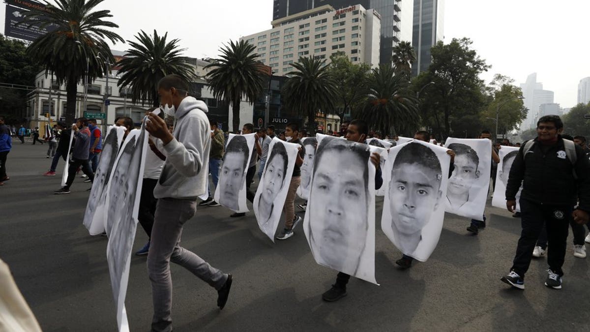 College students join family members of 43 missing students from the Rural Normal School of Ayotzinapa in a march marking the sixth anniversary of the 43 students' enforced disappearance, in Mexico City, Saturday, Sept. 26, 2020. (AP Photo/Rebecca Blackwell)