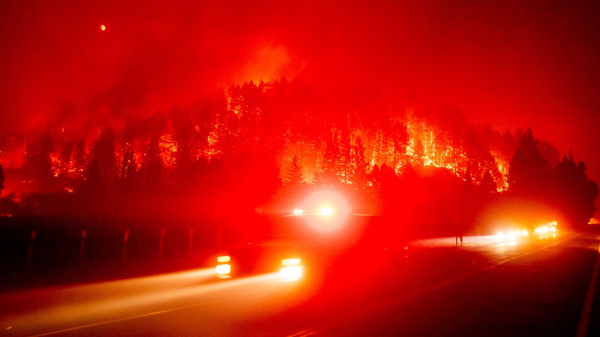 An emergency vehicle drives along Silverado Trail as the Glass Fire burns in St. Helena, Calif., Sunday, Sept. 27, 2020.
