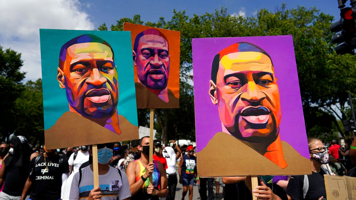 People carry posters with George Floyd on them as they march from the Lincoln Memorial to the Martin Luther King Jr. Memorial during the March on Washington, Friday Aug. 28, 2020, in Washington.