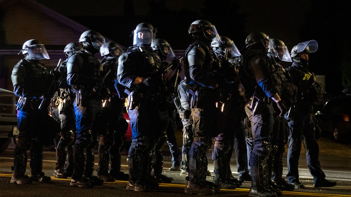 Portland police take control of the streets after making arrests on the scene of the nightly protests at a Portland police precinct on Sunday, Aug. 30, 2020, in Portland, Ore. (AP Photo/Paula Bronstein)
