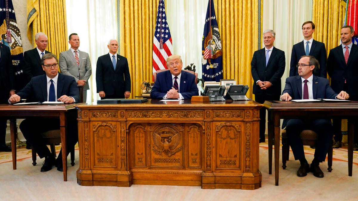 President Donald Trump participates in a signing ceremony with Serbian President Aleksandar Vucic, seated left, and Kosovar Prime Minister Avdullah Hoti, seated right, in the Oval Office of the White House, Friday, Sept. 4, 2020, in Washington. (AP Photo/Evan Vucci)