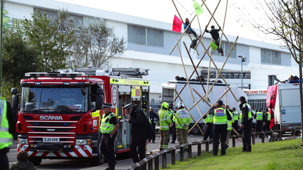 Police and fire services at the scene, outside Broxbourne newsprinters as protesters continue to block the road, in Broxbourne, Hertfordshire, England, Saturday, Sept. 5, 2020. (Yui Mok/PA via AP)