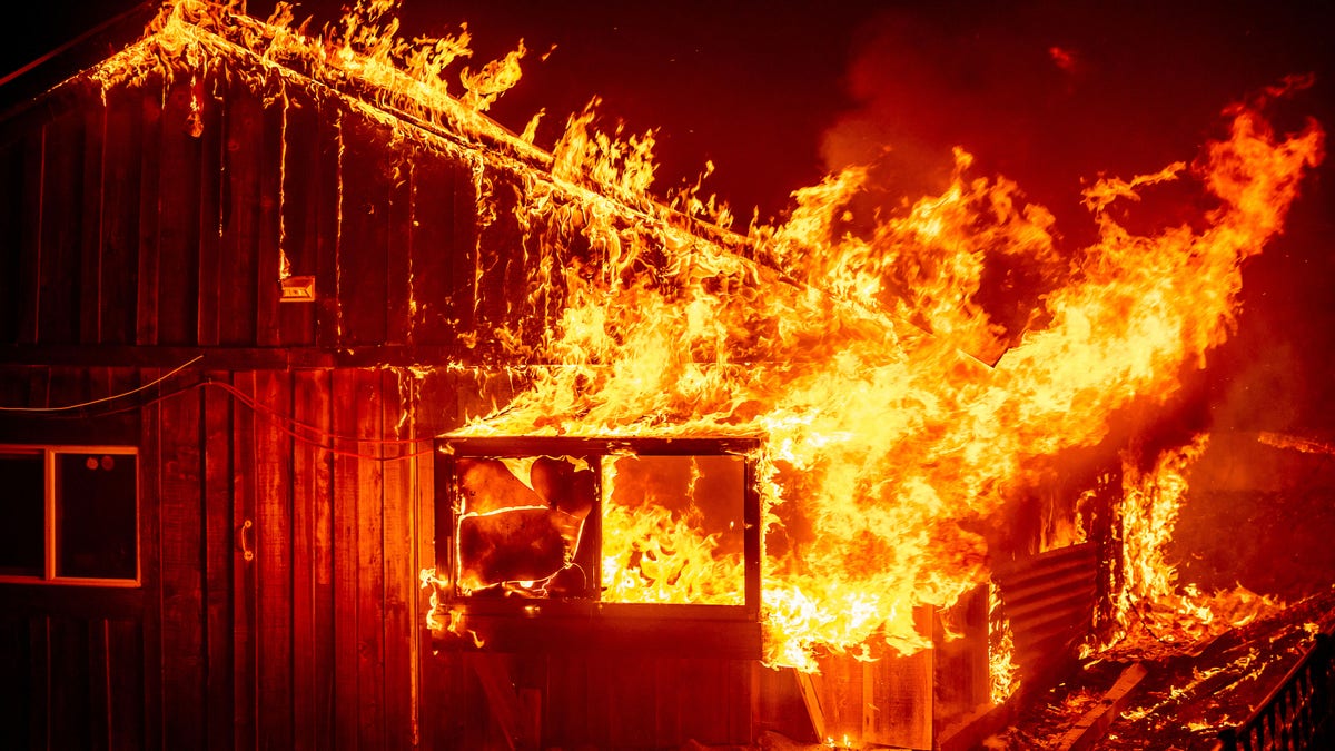 Flames shoot from a home as the Bear Fire burns through the Berry Creek area of Butte County, Calif., on Wednesday, Sept. 9, 2020.