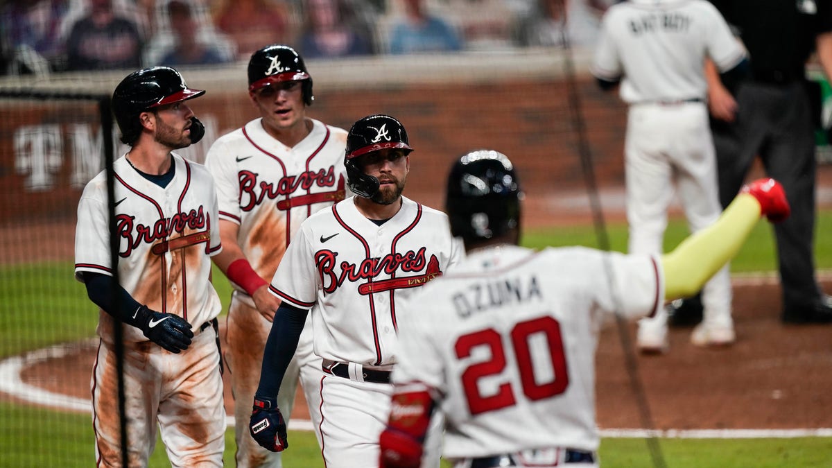 Atlanta Braves' Dansby Swanson, left, Ender Inciarte, center, and Austin Riley return to the dugout after scoring in a double by Ronald Acuna Jr. during the sixth inning of a baseball game against the Miami Marlins on on Wednesday, Sept. 9, 2020, in Atlanta. (Associated Press)