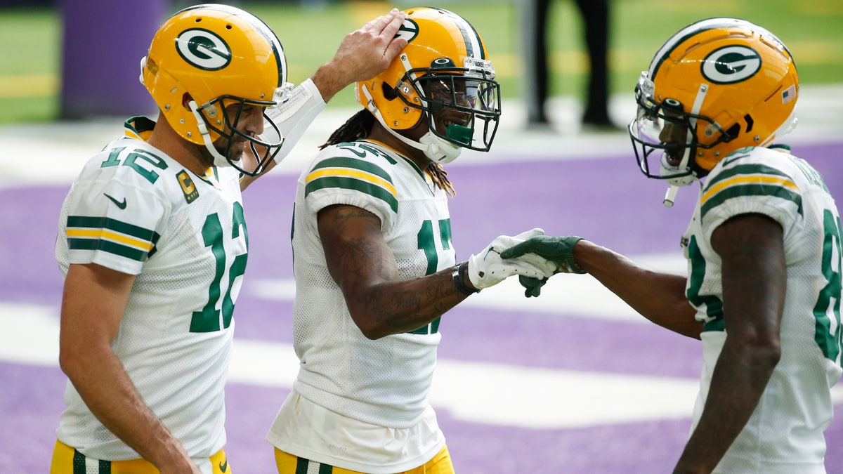 Green Bay Packers wide receiver Davante Adams, center, celebrates with teammates Aaron Rodgers, left, and Marquez Valdes-Scantling, right, after catching a 1-yard touchdown pass during the second half of an NFL football game against the Minnesota Vikings, Sunday, Sept. 13, 2020, in Minneapolis. (AP Photo/Bruce Kluckhohn)
