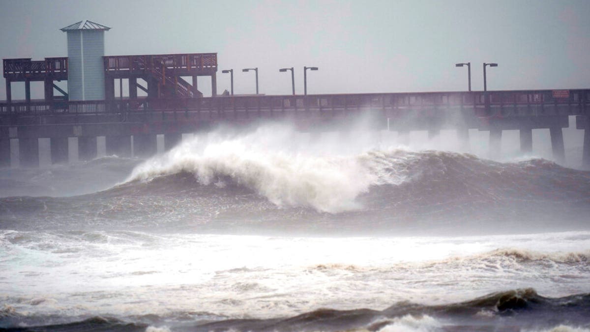Waves crash near a pier, at Gulf State Park, Sept. 15, in Gulf Shores, Ala. Hurricane Sally is crawling toward the northern Gulf Coast at just 2 mph, a pace that's enabling the storm to gather huge amounts of water to eventually dump on land. (AP Photo/Gerald Herbrt)