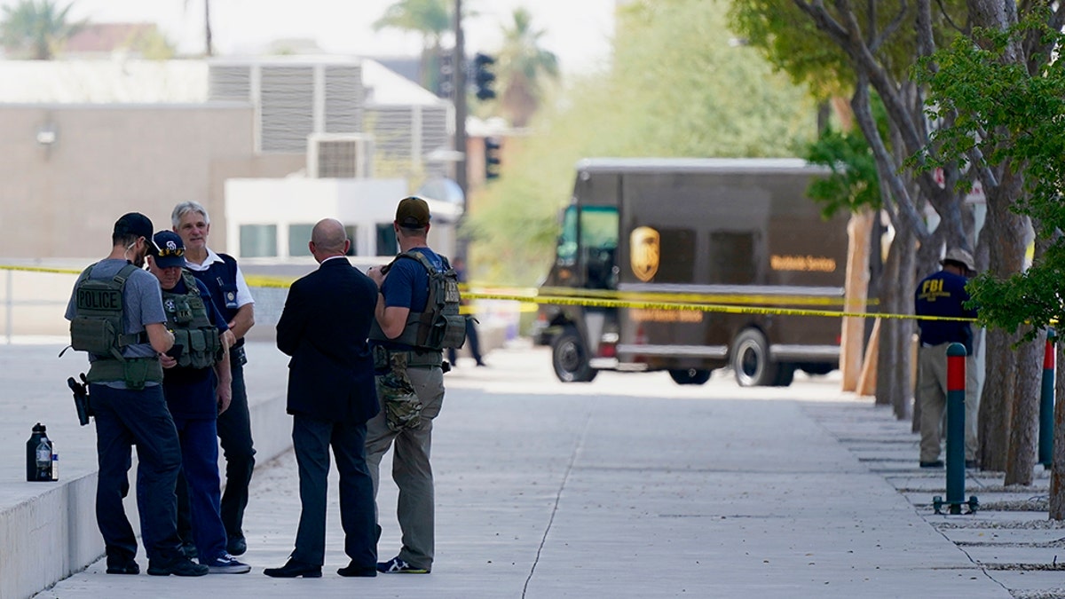 Federal law enforcement personnel stand outside the Sandra Day O'Connor Federal Courthouse Sept. 15, in Phoenix. A drive-by shooting wounded a federal court security officer Tuesday outside the courthouse in downtown Phoenix, authorities said. The officer was taken to a hospital and is expected to recover, according to city police and the FBI, which is investigating. (AP Photo/Ross D. Franklin)