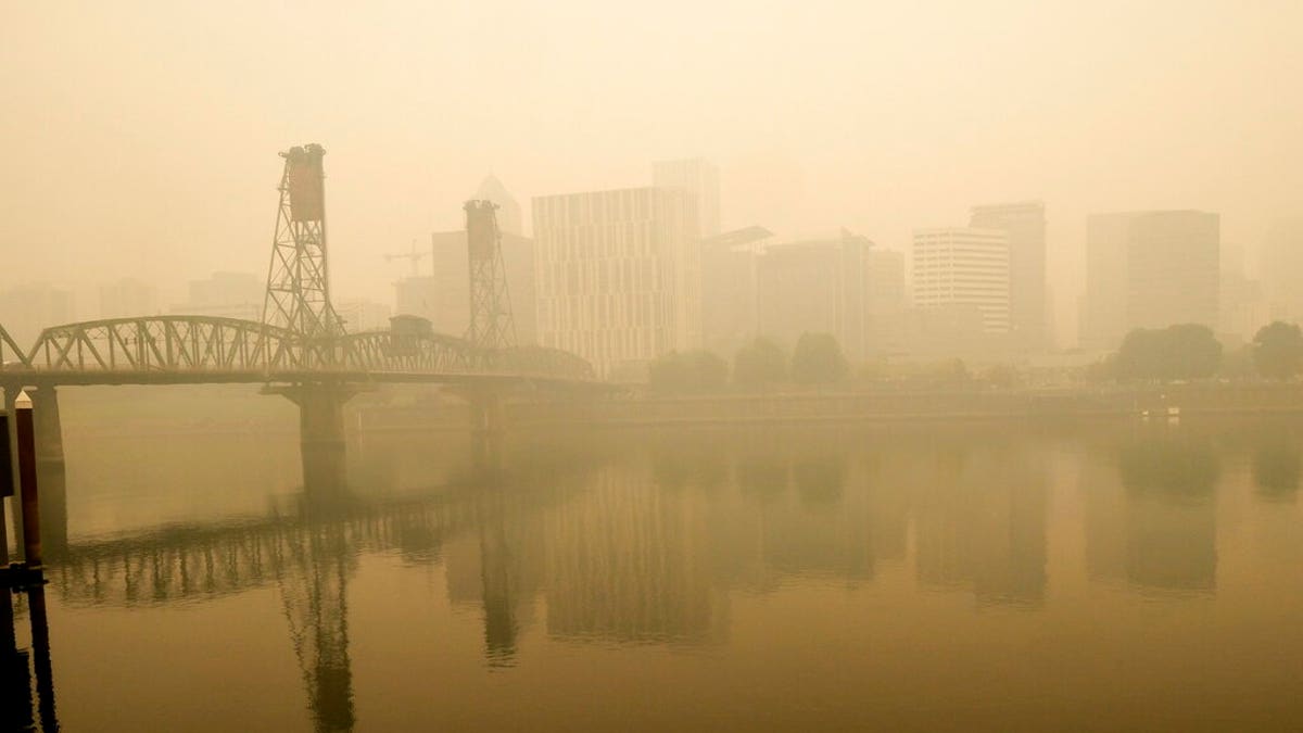 In this photo provided by Don Ryan, heavy smoke from wildfires envelops the Willamette Bridge and downtown Portland, Ore., Sept. 16. Dangerously dirty air spewing from the West Coast wildfires is seeping into homes and businesses, sneaking into cars through air conditioning vents and preventing people already shut away by the coronavirus pandemic from enjoying a walk or trip to the park. (Don Ryan via AP)