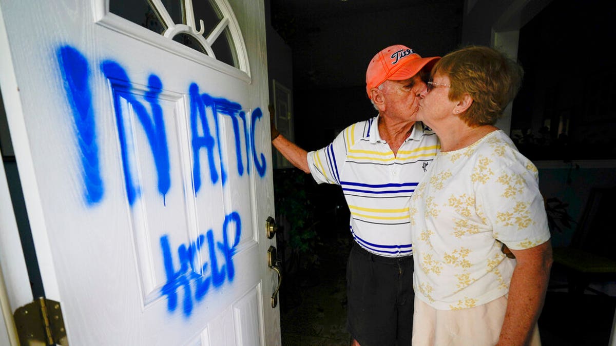 Elaine and Jack Hulgan pose for a portrait after riding out the hurricane in their attic, Sept. 17, in Cantonment, Fla. Rivers swollen by Hurricane Sally's rains threatened more misery for parts of the Florida Panhandle and south Alabama on Thursday, as the storm's remnants continued to dump heavy rains inland that spread the threat of flooding to Georgia and the Carolinas. (AP Photo/Gerald Herbert)