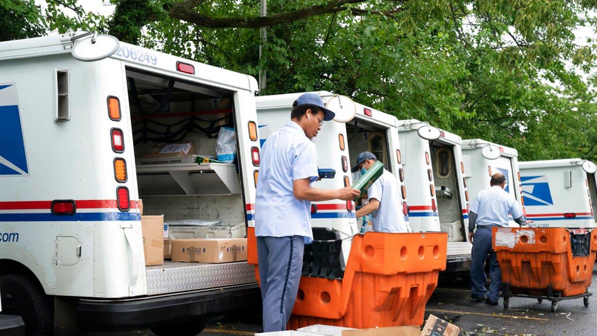 Letter carriers load mail trucks for deliveries at a U.S. Postal Service facility in McLean, Va. (AP Photo/J. Scott Applewhite)