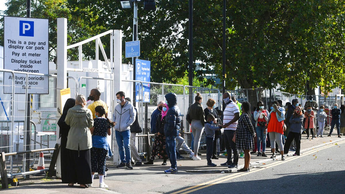 People queue up outside a coronavirus testing centre offering walk-in appointments in north London, Friday Sept. 18, 2020. (Kirsty O'Connor/PA via AP)