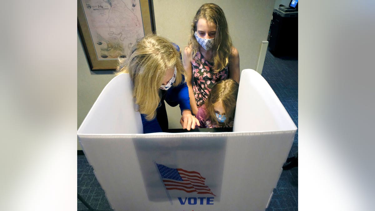 U.S Rep. Abigail Spanberger, D-Va., gets help from daughters Claire, 12, center and Charlotte, 9, as she marks her ballot to vote in the general election at the Henrico County general registrar's office in Henrico County, Va., Friday, Sept. 18, 2020, on the first day of the state's 45-day early voting period.