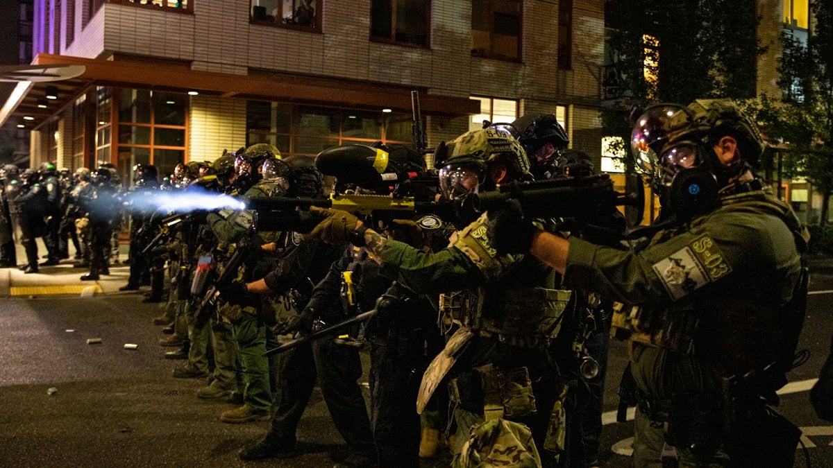 Federal police try to take control of the streets during protests, Friday, Sept. 18, 2020, in Portland, Ore. Oregon Gov. Kate Brown declared a state of emergency Friday in anticipation of a rally planned in Portland over the weekend that could potentially turn violent. (AP Photo/Paula Bronstein)