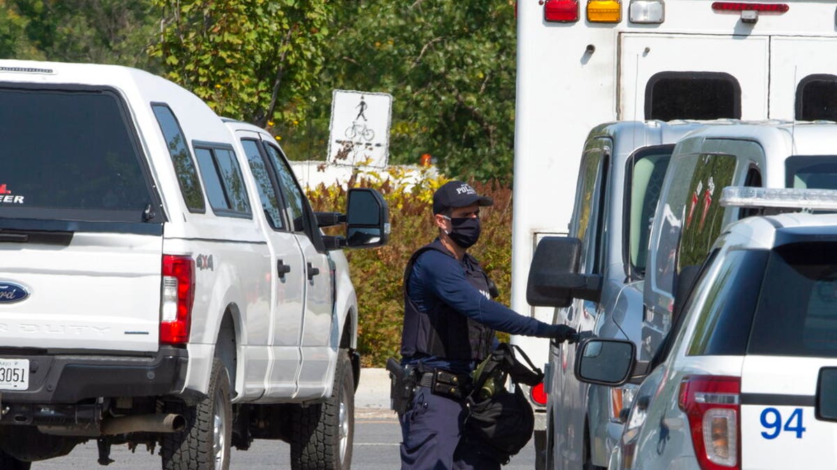 A Royal Canadian Mounted Police officer walks outside of an apartment complex Monday, Sept. 21, 2020, in St-Hubert, Quebec, during a raid in connection with an envelope containing the poison ricin, which was addressed to the White House. 