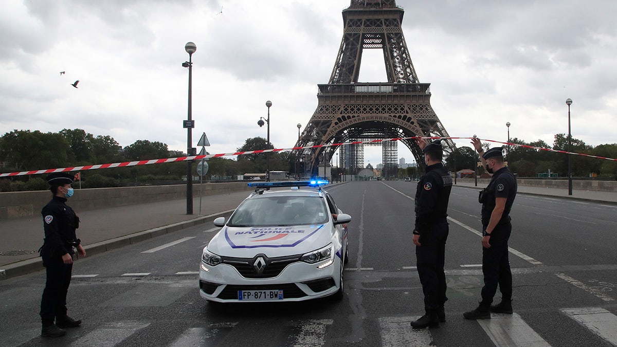 French police officers secure the bridge leading to the Eiffel Tower, Wednesday, Sept. 23, 2020, in Paris. Paris police have blockaded the area around the Eiffel Tower after a phone-in bomb threat. (AP Photo/Michel Euler)