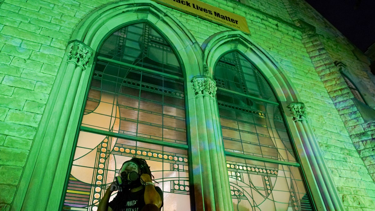 A protester wears a gas mask outside The First Unitarian Church, Thursday, Sept. 24, 2020, in Louisville, Ky. (Associated Press)