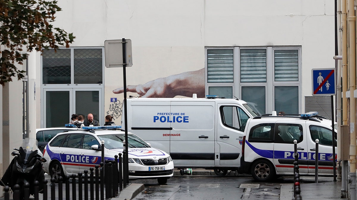 Police car park outside a building after four people have been wounded in a knife attack near the former offices of satirical newspaper Charlie Hebdo on Sept. 25, 2020 in Paris. (AP Photo/Thibault Camus)