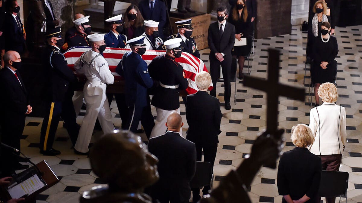 A joint services military honor guard carries the flag-draped casket of Justice Ruth Bader Ginsburg to lie in state in Statuary Hall of the U.S. Capitol, Friday, Sept. 25, 2020, in Washington. (Olivier Douliery/Pool via AP)