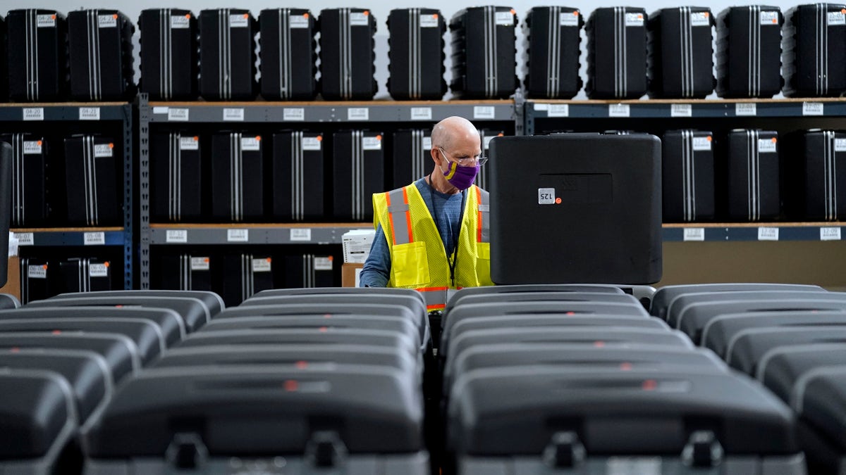 In this Sept. 3, 2020, file photo, a worker prepares tabulators at the Wake County Board of Elections in Raleigh, N.C. The coronavirus pandemic is forcing millions of American voters worried about their health to vote by mail for the first time. (AP Photo/Gerry Broome)