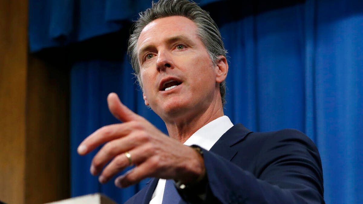 FILE: Gov. Gavin Newsom talks to reporters at his Capitol office in Sacramento, Calif. California will attempt to use its massive market power to increase the availability and lower the cost of prescription drugs.?