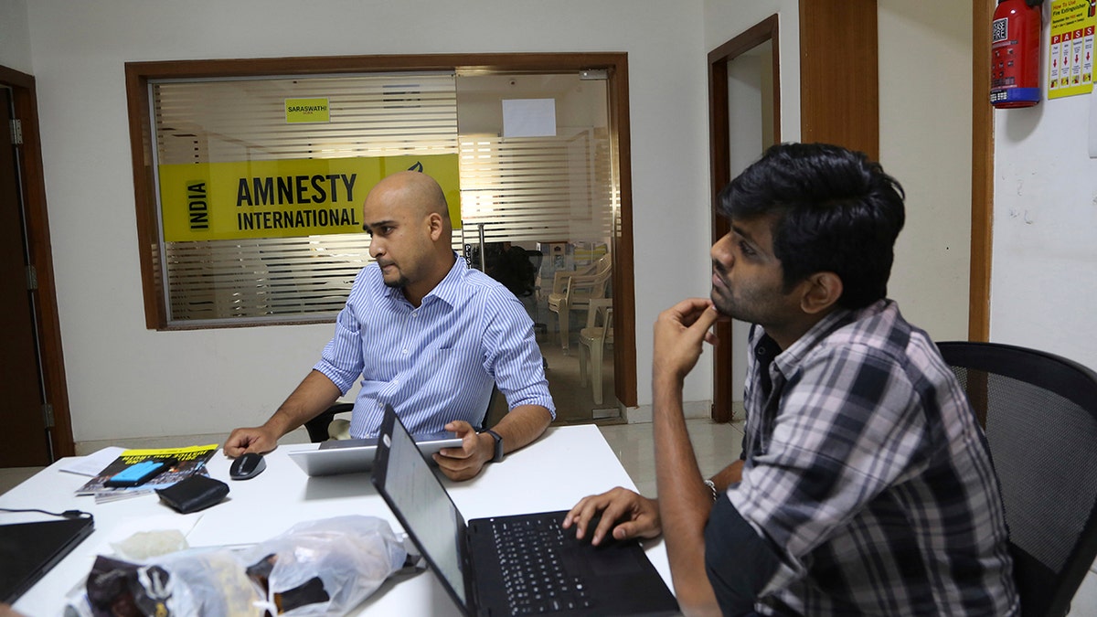 FILE - In this Tuesday, Feb. 5, 2019, file photo, Amnesty International India employees work at their headquarters in Bangalore, India. (AP Photo/Aijaz Rahi, File)