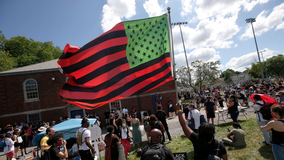 A stylized American Black Lives Matter flag flies during a Juneteenth rally, Friday, June 19, 2020, in Boston. Juneteenth commemorates when the last enslaved African Americans learned in 1865 they were free, more than two years following the Emancipation Proclamation. (AP Photo/Michael Dwyer)