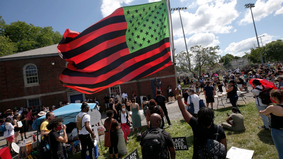 A stylized American Black Lives Matter flag flies during a Juneteenth rally, Friday, June 19, 2020, in Boston. Juneteenth commemorates when the last enslaved African Americans learned in 1865 they were free, more than two years following the Emancipation Proclamation. (AP Photo/Michael Dwyer)