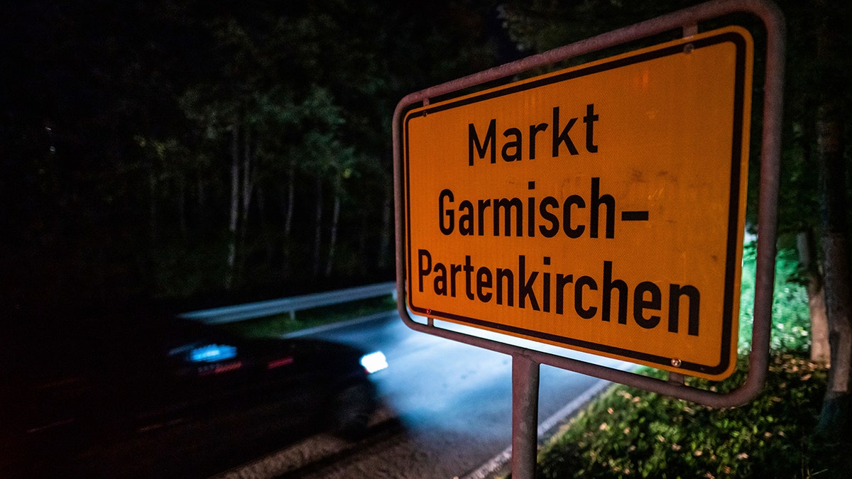 In this Sept. 13 photo, a car drives past the place name sign in Garmisch-Partenkirchen, Germany. Officials in southern Germany are considering imposing hefty fines against a 26-year-old American woman linked to a cluster of coronavirus cases in the Alpine resort town of Garmisch-Partenkirchen, including at a hotel that caters to U.S. military personnel. (Lino Mirgeler/dpa via AP)