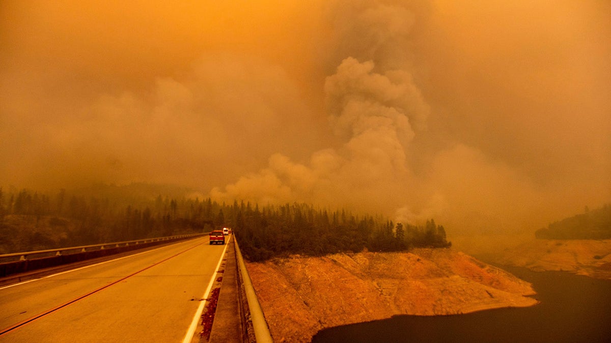 A plume rises from the Bear Fire as it burns along Lake Oroville on Wednesday, Sept. 9, 2020, in Butte County, Calif.