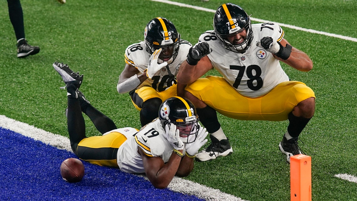 Steelers players stand for national anthem, hold banner before game vs.  Giants