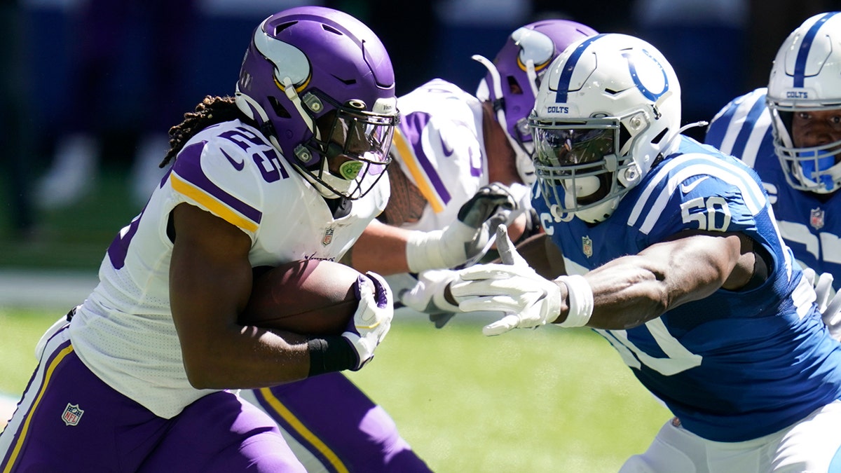 Minnesota Vikings' Alexander Mattison (25) runs past Indianapolis Colts' Justin Houston (50) during the first half of an NFL football game, Sunday, Sept. 20, 2020, in Indianapolis. (AP Photo/Michael Conroy)