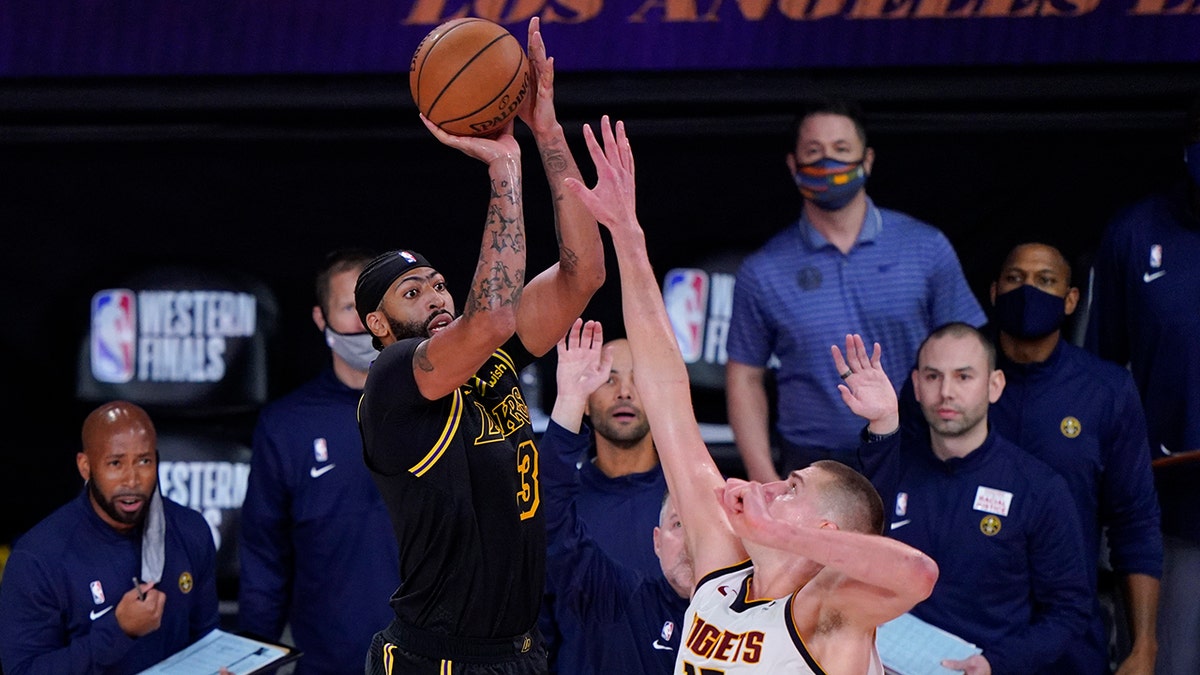 Los Angeles Lakers' Anthony Davis (3) shoots a 3-point basket over Denver Nuggets' Nikola Jokic (15) at the end of an NBA conference final playoff basketball game Sunday, Sept. 20, 2020, in Lake Buena Vista, Fla. The Lakers won 105-103. (AP Photo/Mark J. Terrill)