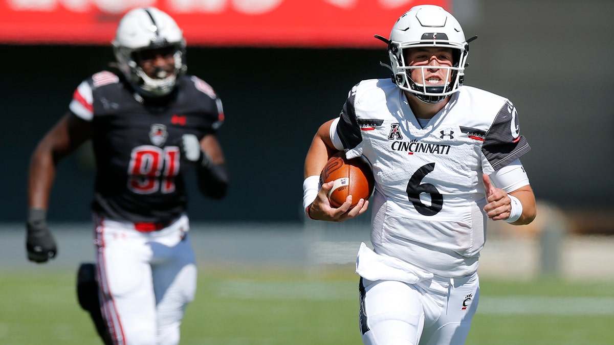 Cincinnati quarterback Ben Bryant, right, breaks away from the Austin Peay defense to score a touchdown during the second half of an NCAA college football game Saturday, Sept. 19, 2020, in Cincinnati, Ohio. Cincinnati beat Austin Peay 55-20. (AP Photo/Jay LaPrete)