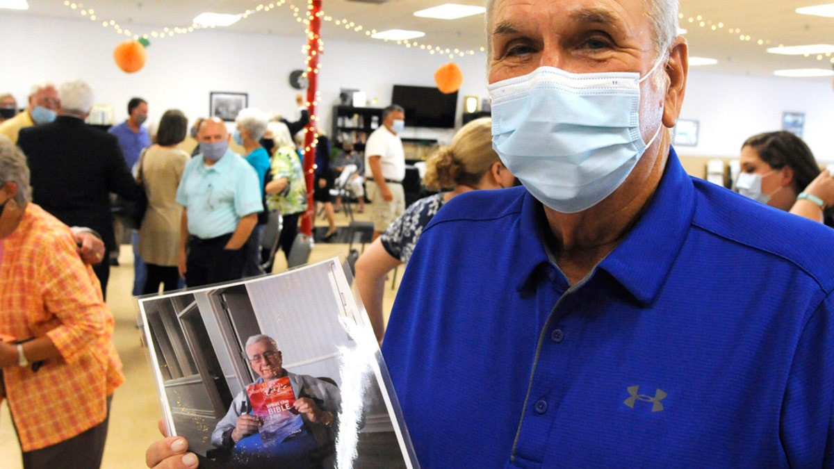 Don Driver, the younger brother of the late Mayor Billy Joe Driver, holds a photo of the longtime public official after a memorial service in Clanton, Ala., on Friday, Aug. 28, 2020.  (AP Photo/Jay Reeves)