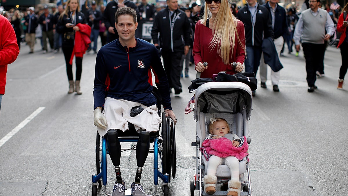 United States Air Force Senior Airman Brian Kolfage, a triple amputee who lost both his legs and an arm while serving his second deployment in Iraq in 2004, attends the Veterans Day parade with his wife Ashley in New York City in 2014. (Reuters)