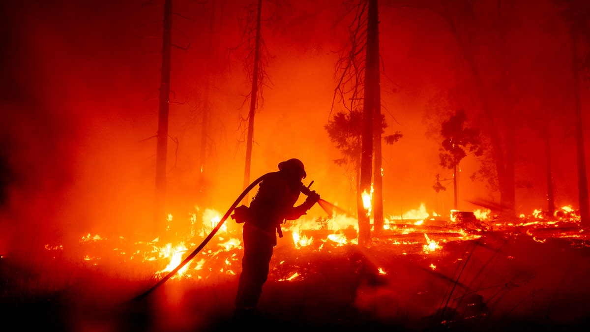 In this Sept. 7, 2020, file photo, a firefighter battles the Creek Fire as it threatens homes in the Cascadel Woods neighborhood of Madera County, Calif.