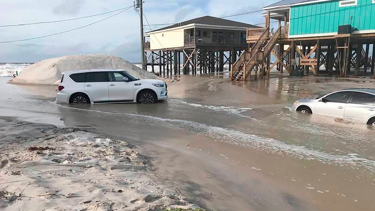 This photo provided by Dauphin Island Mayor Jeff Collier shows cars stranded in the sand, as flooding continues in Tonty Court on Dauphin Island, Ala., Monday, Sept 14, 2020, as Sally closes in on the Gulf Coast.