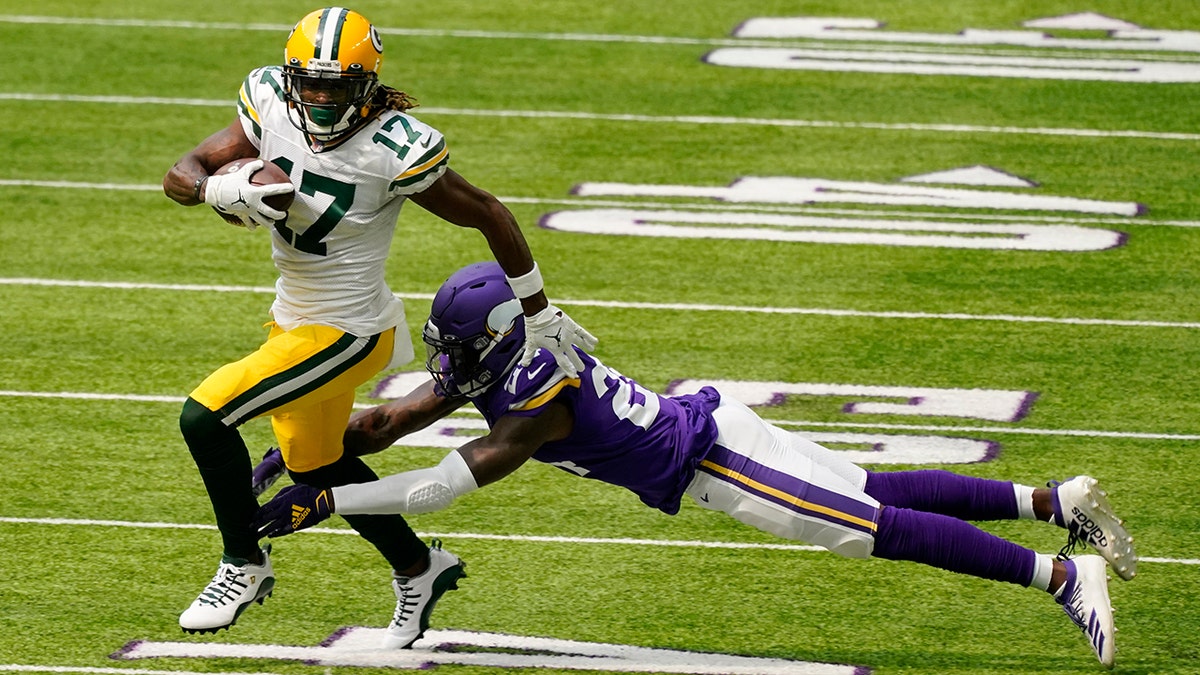 Green Bay Packers wide receiver Davante Adams breaks a tackle by Minnesota Vikings defensive back Holton Hill (24) during the first half of an NFL football game, Sunday, Sept. 13, 2020, in Minneapolis. (AP Photo/Jim Mone)