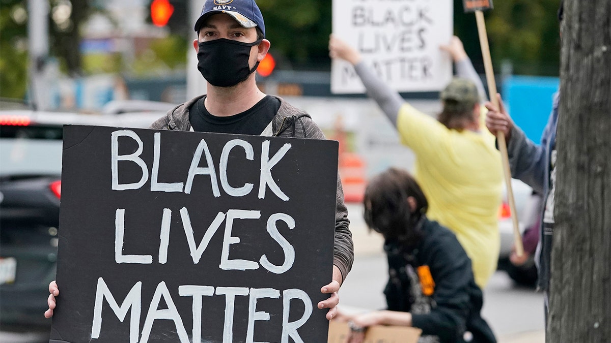 A protester holds up a Black Lives Matter sign near the debate hall, Tuesday, Sept. 29, 2020, in Cleveland. The first presidential debate between Republican candidate President Donald Trump and Democratic candidate and former Vice President Joe Biden is being held in Cleveland Tuesday. (AP Photo/Tony Dejak)