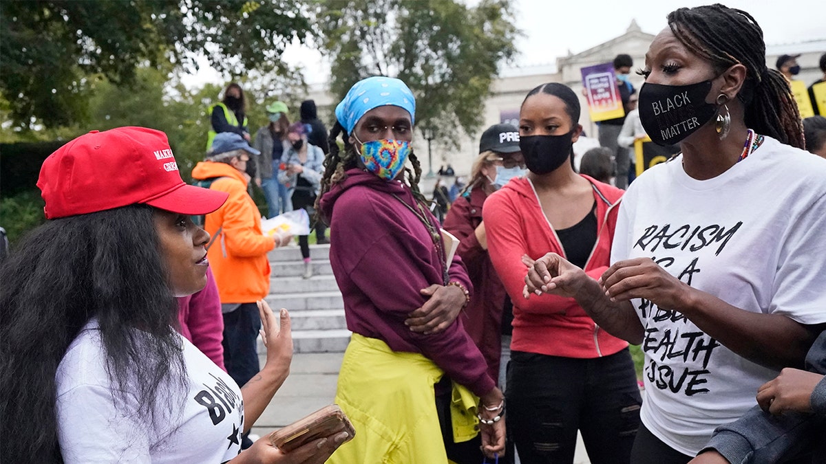 A Trump supporter and a protester argue near the debate hall, Tuesday, Sept. 29, 2020, in Cleveland. The first presidential debate between Republican candidate President Donald Trump and Democratic candidate and former Vice President Joe Biden is being held in Cleveland Tuesday. (AP Photo/Tony Dejak)