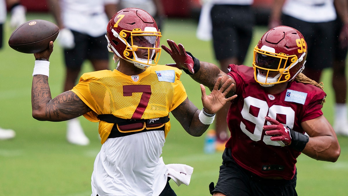 Washington quarterback Dwayne Haskins Jr. (7) passes under pressure from defensive end Chase Young (99) during an NFL football practice at FedEx Field, Monday, Aug. 31, 2020, in Washington. (AP Photo/Alex Brandon)
