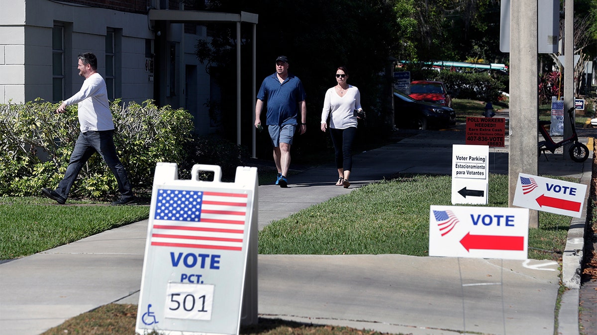 In this March 17, photo, voters head to a polling station to vote in Florida's primary election in Orlando, Fla. Florida felons must pay all fines, restitution and legal fees before they can regain their right to vote, a federal appellate court ruled Sept, 11. (AP Photo/John Raoux, File)