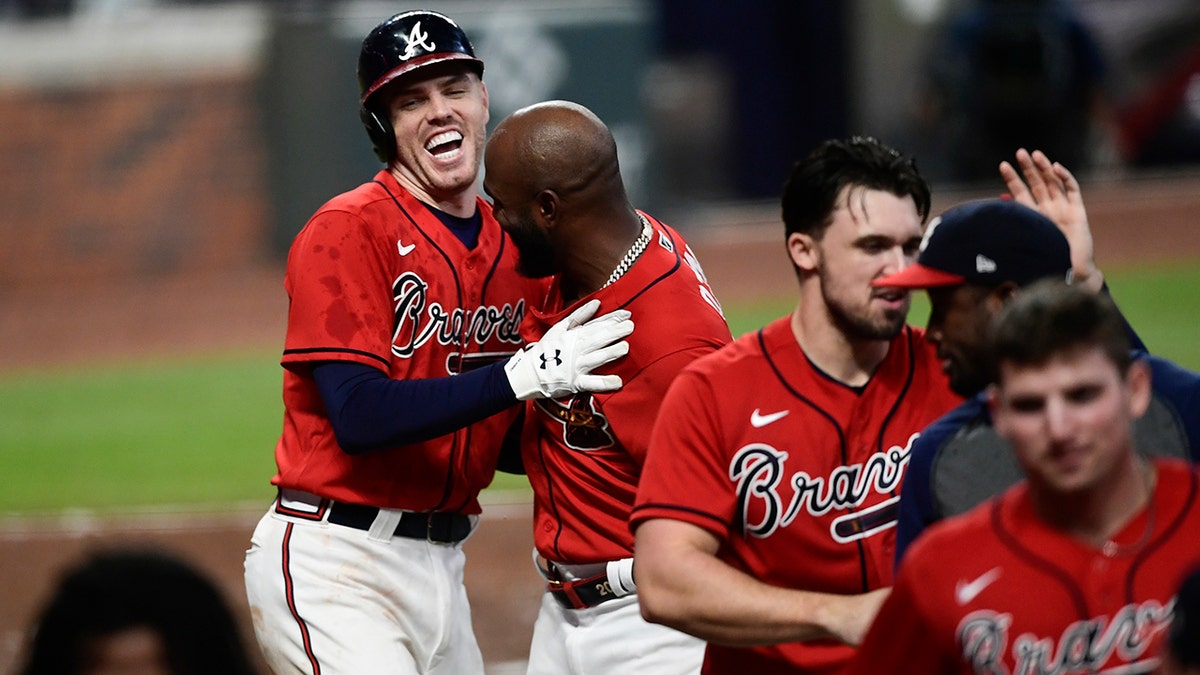 Atlanta Braves' Freddie Freeman, top left, celebrates his winning two-run home with teammates during the 11th inning of a baseball game against the Boston Red Sox, Friday, Sept. 25, 2020, in Atlanta. (AP Photo/John Amis)