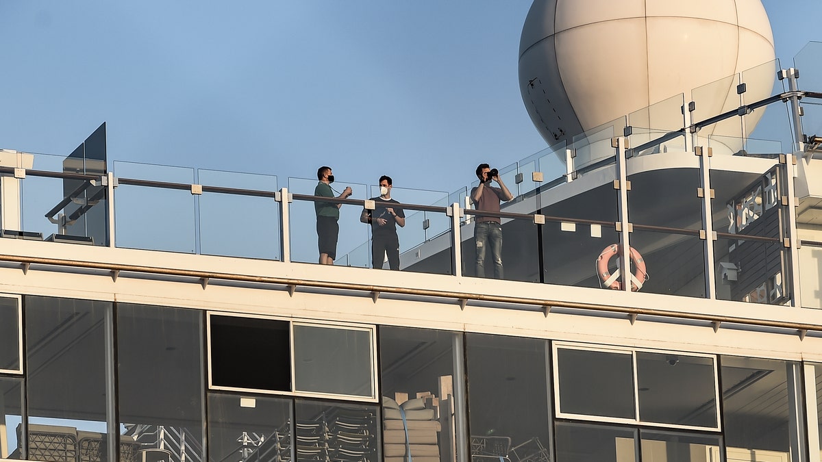 Passengers of the Mein Schiff 6 cruise ship stand outside their cabins as the ship is docked at Piraeus port, near Athens on Sept. 29. (Dimitris Lampropoulos/NurPhoto via Getty Images)