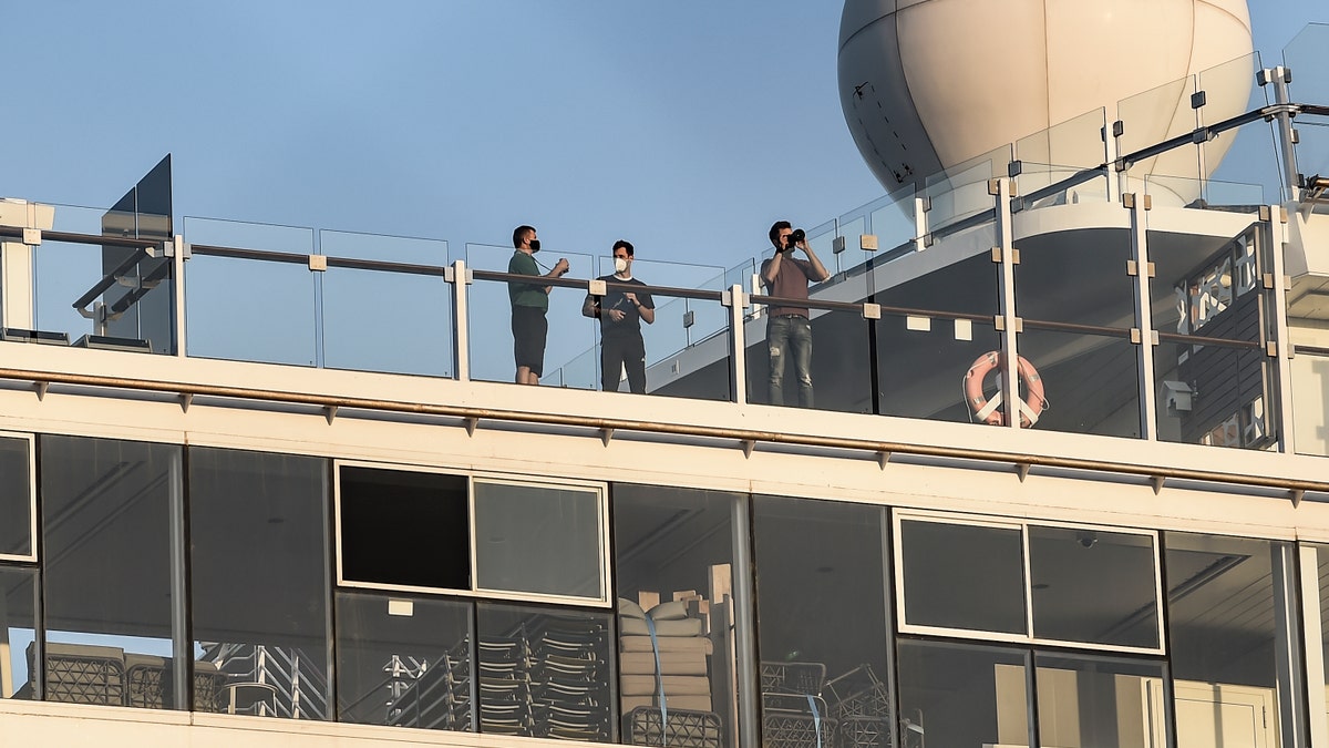 Passengers of the Mein Schiff 6 cruise ship stand outside their cabins as the ship is docked at Piraeus port, near Athens on Sept. 29. (Dimitris Lampropoulos/NurPhoto via Getty Images)