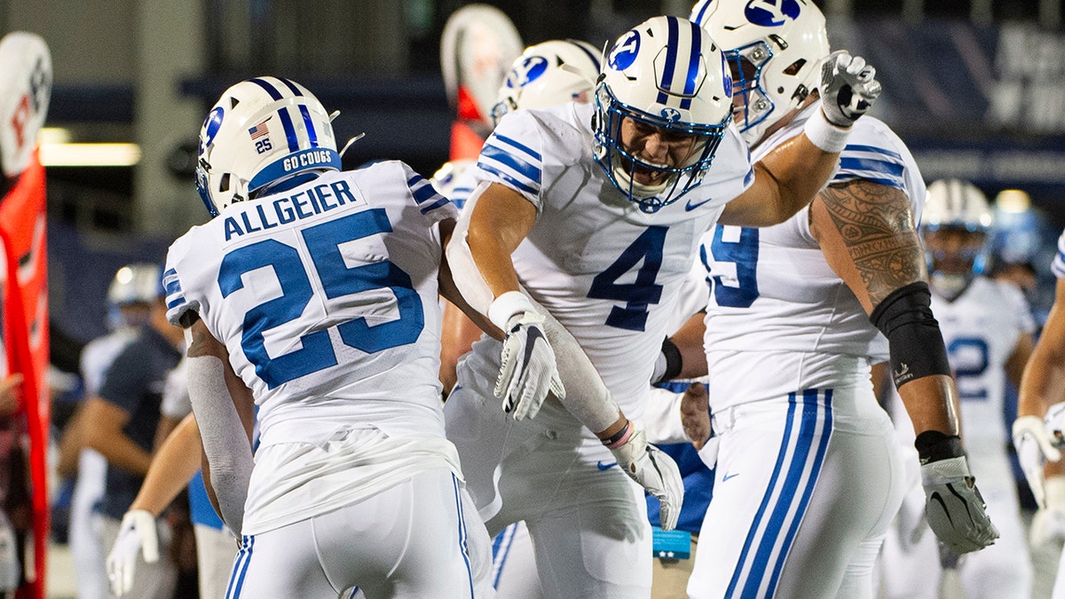 BYU's Lopini Katoa (4) and Tyler Allgeier (25) celebrate during the first half of an NCAA college football game against Navy, Monday, Sept. 7, 2020, in Annapolis, Md. (AP Photo/Tommy Gilligan)