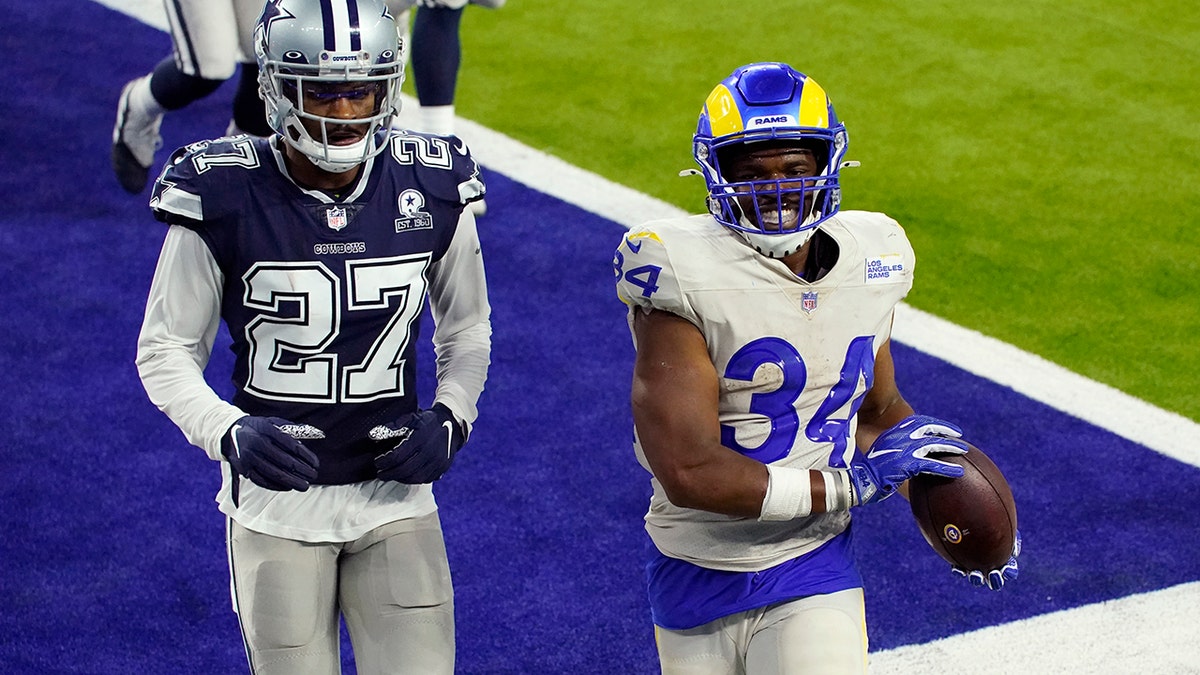 Los Angeles Rams running back Malcolm Brown (34) smiles after scoring a rushing touchdown next to Dallas Cowboys defensive back Trevon Diggs (27) during the second half of an NFL football game Sunday, Sept. 13, 2020, in Inglewood, Calif. (AP Photo/Ashley Landis)