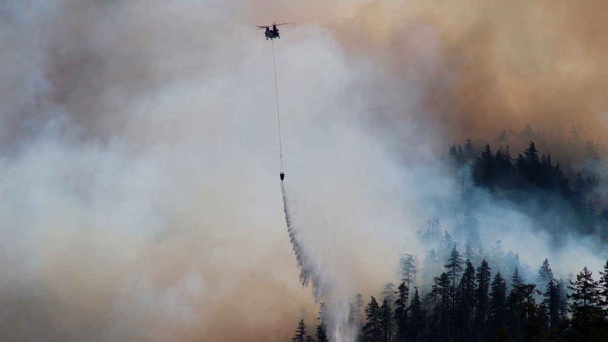 In this Sept. 3, 2020, photo provided by the Opal Creek Ancient Forest Center, fire retardant is dropped at Jawbone Flats in the Opal Creek Wilderness in Oregon.